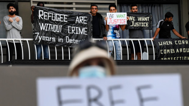 A refugee supporter holds up a sign as asylum seekers protest their detention at an inner city motel.