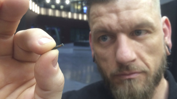 Self-described “body hacker” Jowan Osterlund from Biohax Sweden, holds a small microchip implant, similar to those implanted into workers in Sweden.