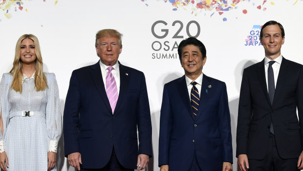 President Donald Trump poses for a photo with Japanese Prime Minister Shinzo Abe and Ivanka Trump and senior advisor Jared Kushner ahead of a meeting on the sidelines of the G20 summit in Osaka.