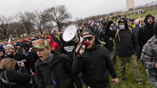 Ethan Nordean, with backward baseball hat and bullhorn, leads members of the far-right group Proud Boys in marching before the riot at the US Capitol. 