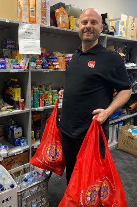TAFE Queensland international support officer Jared Hopkins preparing bags of non-perishable items for international students facing financial hardship during COVID-19.