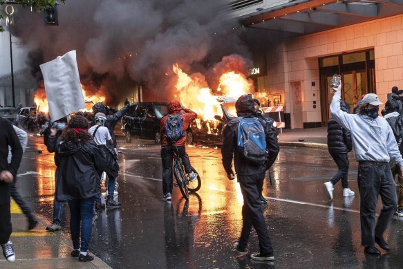 People set fire to vehicles during a protest in Seattle on Saturday. 