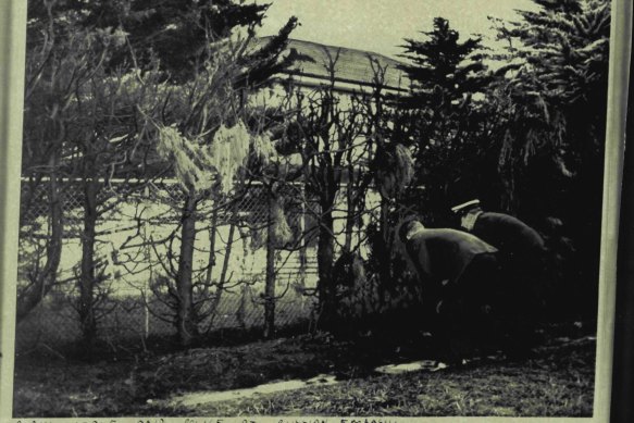 The fire-blackened hedge around the Soviet embassy is searched by police in 1969.