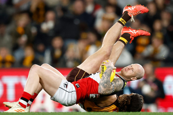 Zak Jones (St Kilda) grapples with Hawthorn’s Jai Newcombe before he left the ground injured.