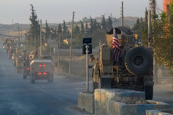 US military vehicles travel down a main road in north-east Syria on October 7.