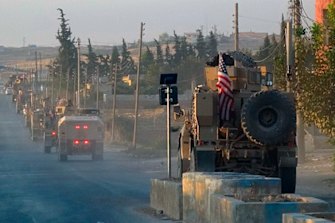 US military vehicles travel down a main road in northeast Syria on October 7.