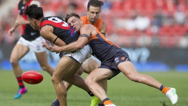 Welcome back: Stephen Coniglio dispossesses former GWS teammate Dylan Shiel, now with Essendon.