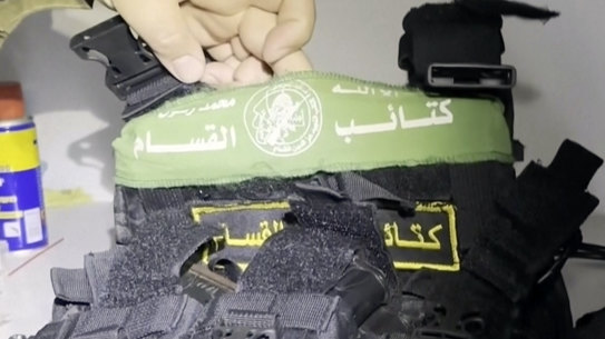 An Israeli military spokesman holds up a bulletproof vest with a Hamas insignia found along with weapons the IDF says were found in a medical closet at the al-Shifa hospital in Gaza City.