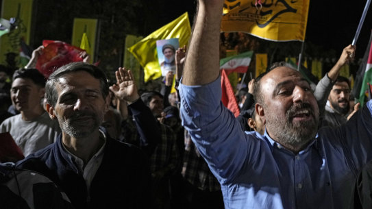 Demonstrators cheer as they wave Iranian and other flags in an anti-Israeli gathering celebrating Iran’s missile strike against Israel at Felestin (Palestine) Sqare in Tehran