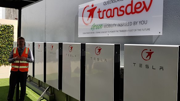 Mr Cleave with the Tesla powerwalls that will power the e-bus.