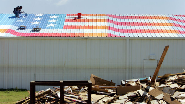 Scott LoBaido paints an American flag on the roof of the Pontchartrain Baptist Church in New Orleans  in  2006. 