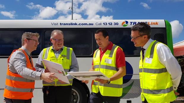 Transdev head of engineering Marc Cleave, Transdev Queensland head of business Mark McKenzie, Capalaba MP Don Brown and TransLink CEO Matt Longland look at mock-ups of the e-bus at the Capalaba depot.