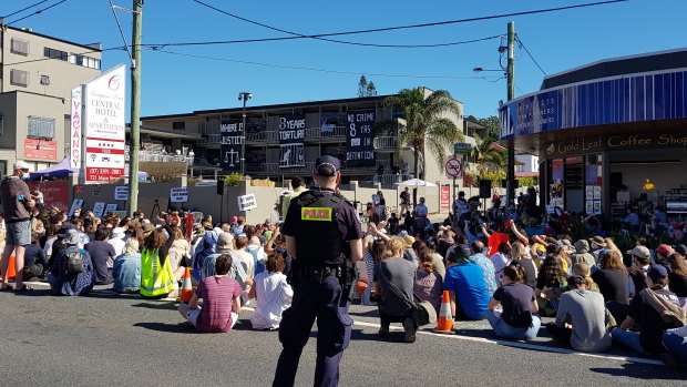 Protesters sat in silence for seven minutes outside the Kangaroo Point hotel where 120 refugees are being kept, to mark seven years of offshore detention.