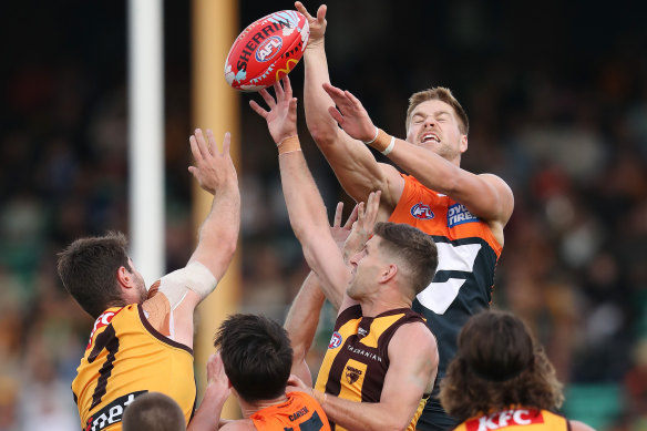 Harry Himmelberg of the Giants over the top of Hawthorn’s Ned Reeves and Luke Breust. 