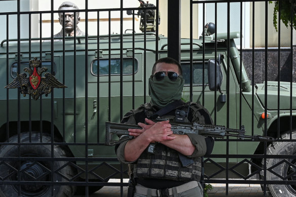 A Wagner fighter stands guard near the headquarters of the Russian southern army military command centre in Rostov-on-Don.