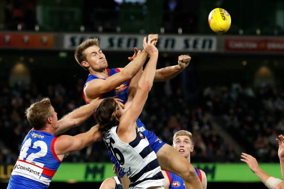 Ryan Gardner of the Bulldogs punches the ball away from Geelong’s Mark Blicavs.