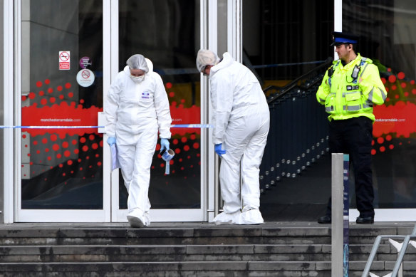 Forensic officers examine the scene of the stabbing at Manchester's Arndale Centre.