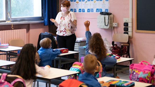 Children wear protective masks inside an elementary school
