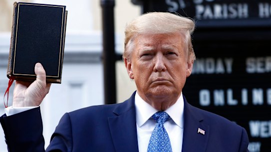 US President Donald Trump holds a Bible as he visits outside St John's Church across Lafayette Park from the White House on Monday.