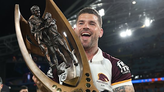 Adam Reynolds celebrates with the NRL trophy on Sunday night.