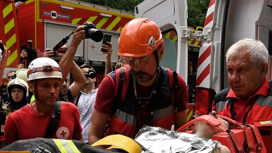 Emergency services rescue Yekaterina Volkova from an apartment building in Kyiv that was hit by a missile attack.