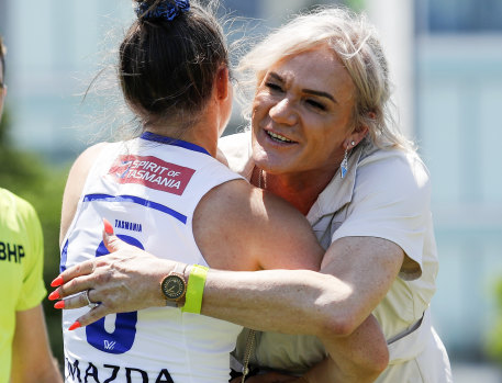 Dani Laidley hugs captain Emma Kearney after tossing the coin for North’s AFLW Pride Round match