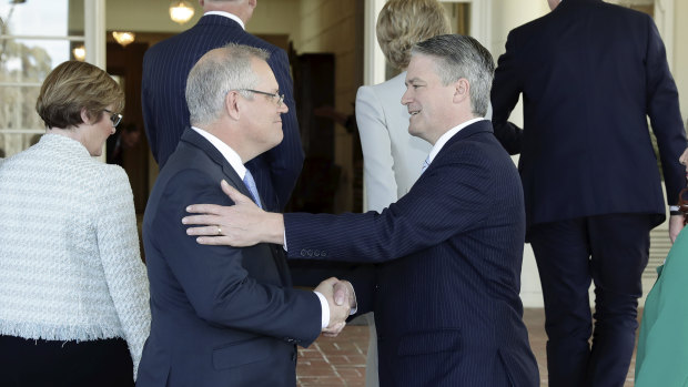 Prime Minister Scott Morrison greets Finance Minister and Dutton backer Mathias Cormann during the swearing-in of the new ministry on Tuesday morning.