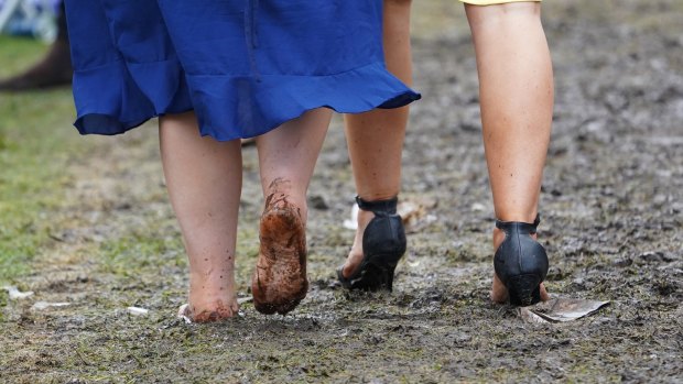 Barefoot racegoers brave the mud.