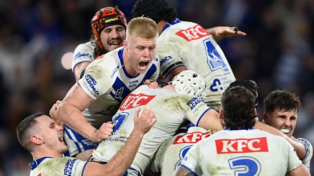 Matt Burton is mobbed by Bulldogs teammates after kicking the winning field goal in golden point.
