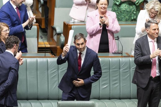 Treasurer Jim Chalmers is congratulated by colleagues after delivering the budget speech.