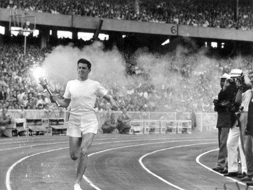 Australian Ron Clarke circles the track in Melbourne Stadium before lighting the Olympic Flame during the 1956 Melbourne Olympics