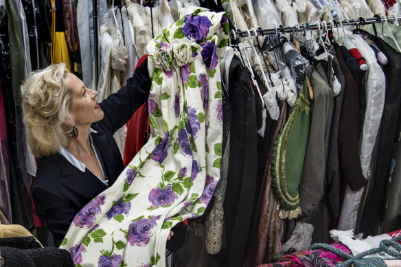 Charlotte Smith holds a 1950s dress that will be part of the sale. 