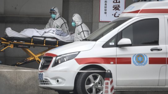 Medical staff transfer patients to hospital in Wuhan.