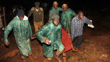 Members of the Kenya's National Youth Service carry away a dead body covered in a blanket during the early hours of Thursday.