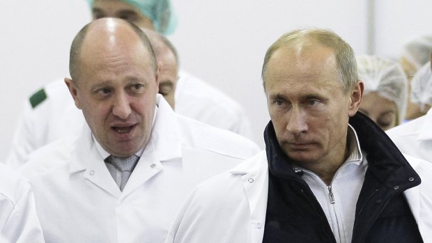 Businessman Yevgeny Prigozhin, left, shows Russian President Vladimir Putin, around his factory which produces school means, outside St. Petersburg, Russia.