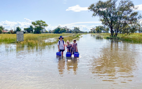 Students Harry, Rachel and Maggie Powell on their way to school at Burren Junction, a small town in between Walgett and Wee Waa in north west NSW, where it is very, very wet.