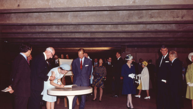 Queen Elizabeth II signs the guest book as she opens the Sydney Opera House "in the presence of her husband" in 1973.