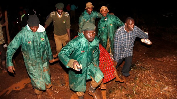 Members of the Kenya's National Youth Service carry away a dead body covered in a blanket during the early hours of Thursday.