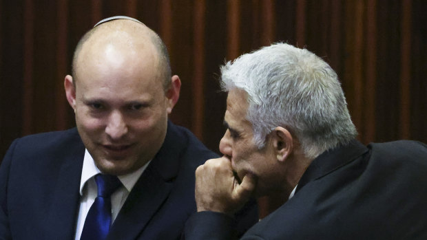 The new PMs: Yamina party leader Naftali Bennett, left, smiles as he speaks to Yesh Atid party leader Yair Lapid.