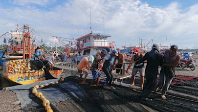 Fishermen unload a trawler in Masinloc.