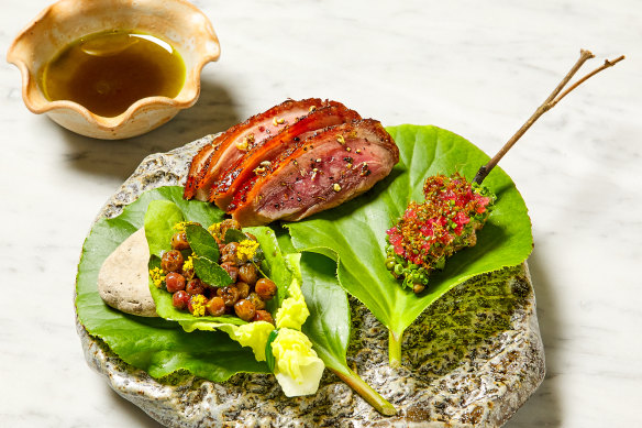 Dry-aged duck presented on a rock and leaves at Botanic restaurant in Adelaide.