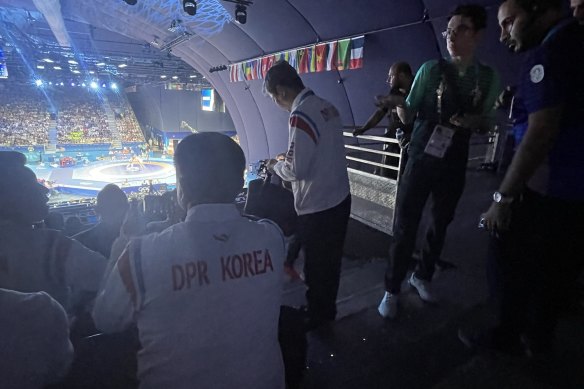 North Korean officials watch their athletes wrestle this week in Paris.