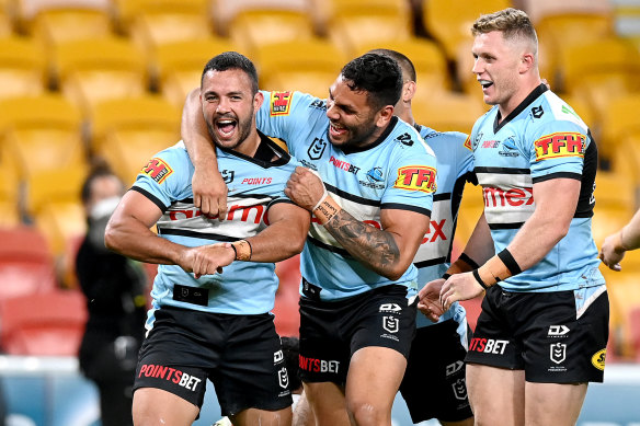 Braydon Trindall (left) celebrates his try for the Sharks against the Broncos.