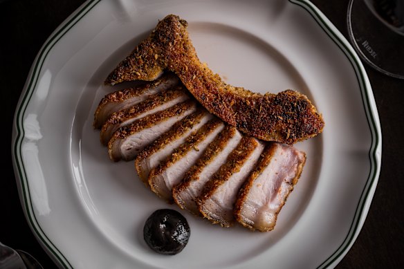 Crackling-crumbed dry-aged pork chop with black garlic at The Hideaway.