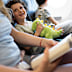 Happy child on airplane journey holding a plush toy while his mother reads.
