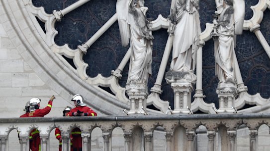 Firefighters assess Notre-Dame's famous rose window after the fire.