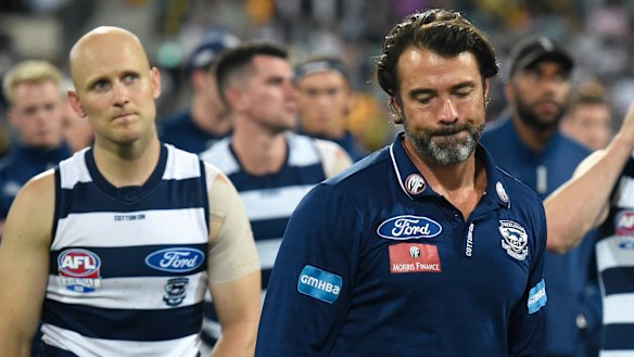 Defeated Geelong coach Chris Scott leads his players from the Gabba