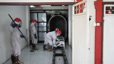 Workers check a cremation machine in Indonesia before cremating a COVID-19 victim.