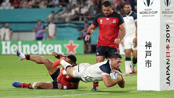 The USA's Bryce Campbell goes over the line to score his team's first try under a tackle from Joe Cokanasiga.