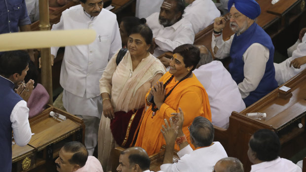 Elected lawmaker Pragya Singh Thakur, in orange dress, who is awaiting trial in connection with a 2008 explosion in Malegaon in western India that killed seven people, greets other lawmakers at an alliance meeting to elect Narendra Modi as their leader in New Delhi, India.  